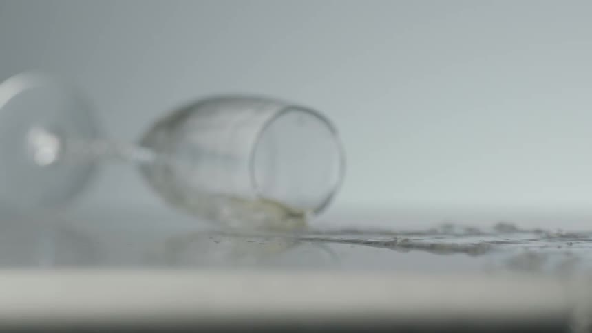 A glass of wine falling on the floor