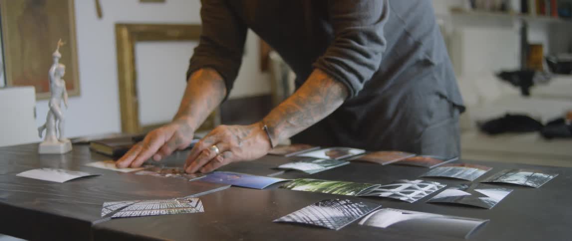 A man moving photos around on a table