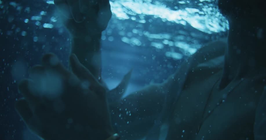 A clothed man is submerged underwater