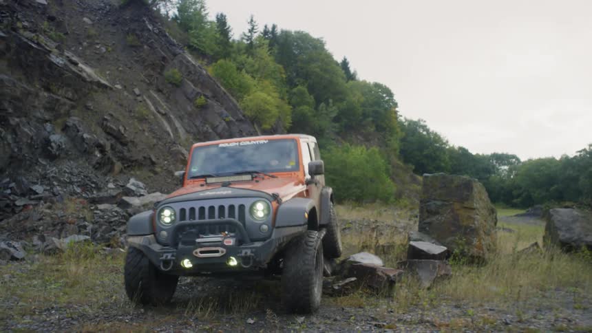 A jeep travels over rocky ground