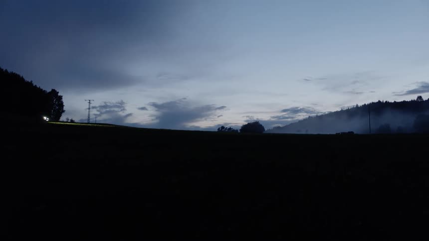 A car is crossing a road after sunset