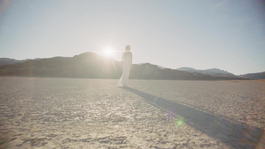 Woman stands outside in the desert on a sunny day