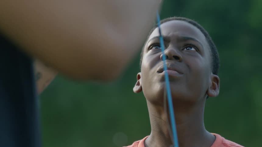 A boy smiles while fishing with a man