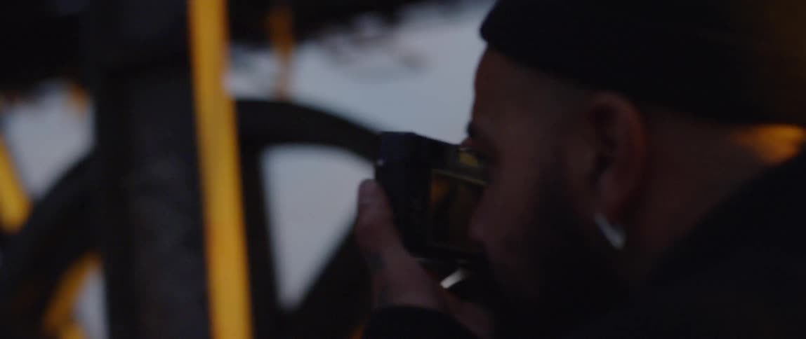 Man takes picture of graffiti on a metal beam