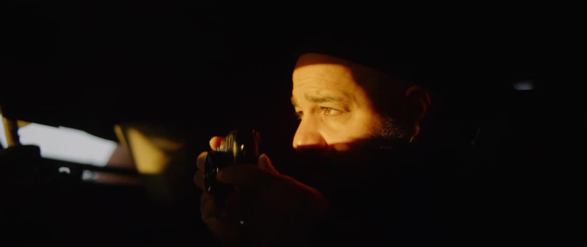 A man takes a photograph at sunset