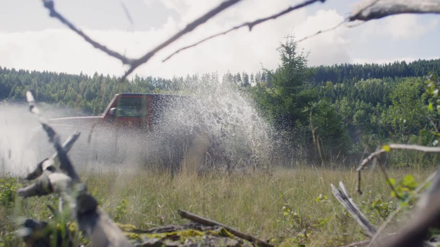 An all terrain vehicle driving through a puddle of water