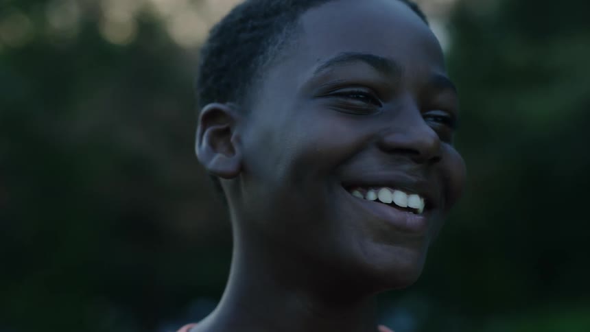 Child is laughing outside and smiling