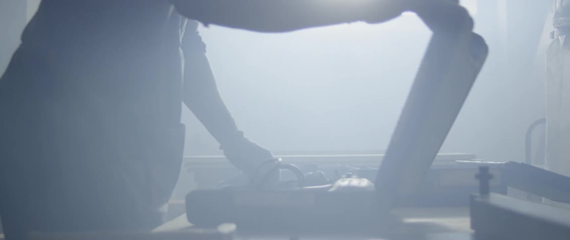 A man opening a briefcase on a dim-lit room