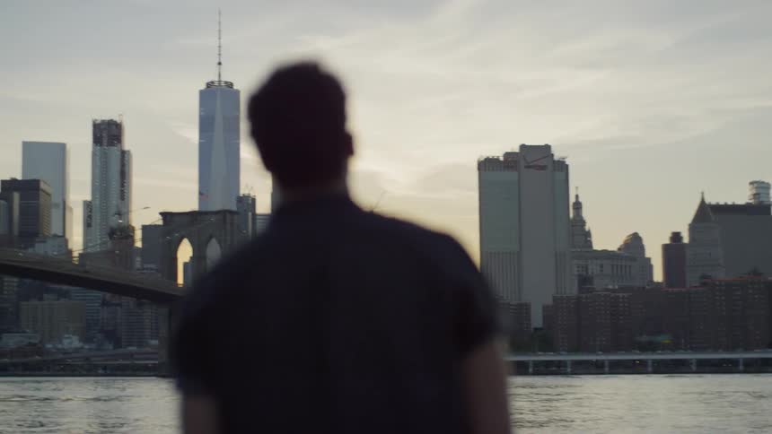 A man standing on the other shore of a city