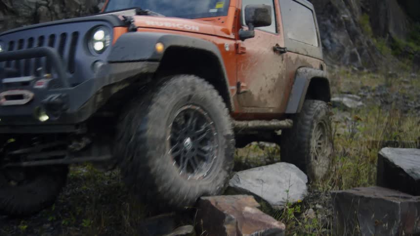 A jeep travels over rocky ground