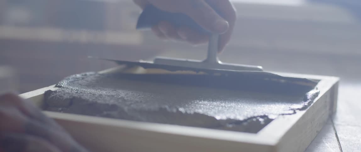Concrete is smoothed in a wood box