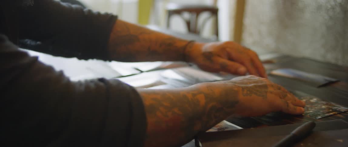 A man moving photos around on a table