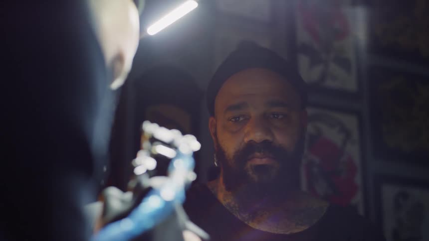 Tattoo artist working on a man