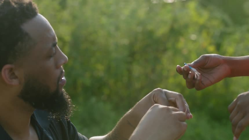 A father and son putting a lure on a fishing pole