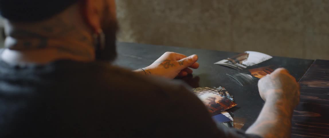 A man is scooping together photos on the table