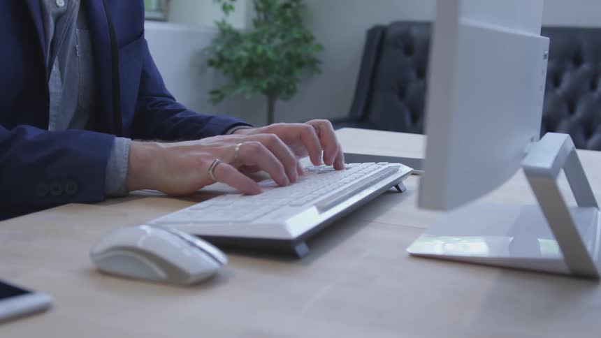 A man is sitting at the desk typing