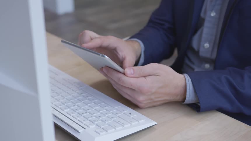 A man uses his tablet by the keyboard