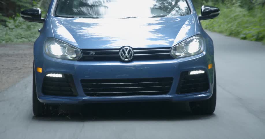 Close up of front of car driving down a rural road