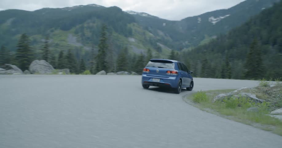 A car races around the corner by the cliff