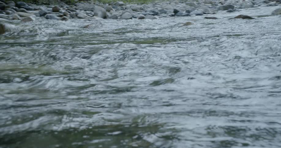 Fast moving river lined with rocks of all sizes