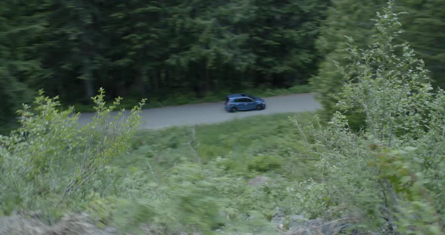 Car goes fast on road in forest on a cloudy day