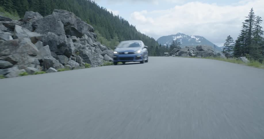 A car is driving fast down a road