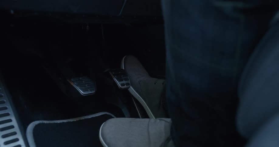 A person rapidly pushing the pedals in a car