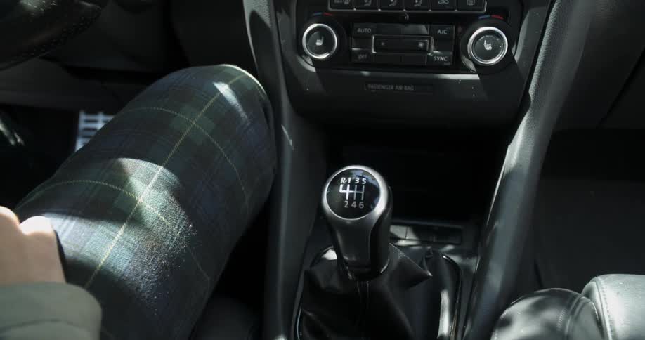 A person pulls the gear shift as they drive