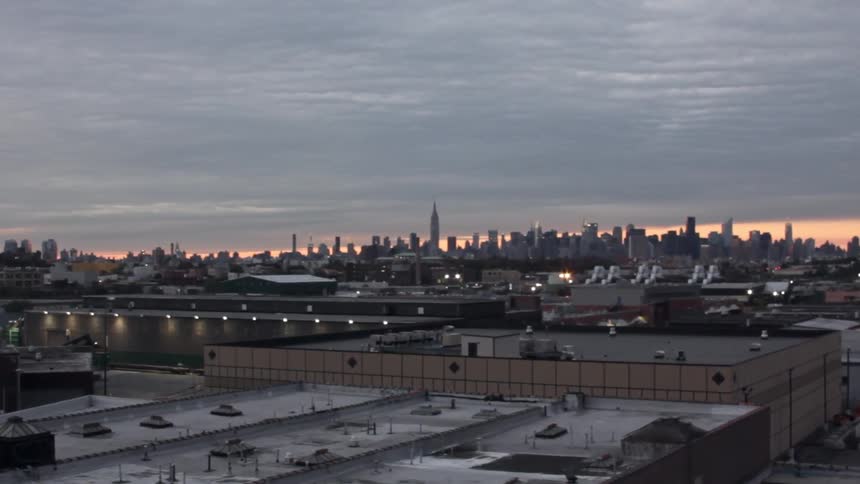 A city at dusk is shown