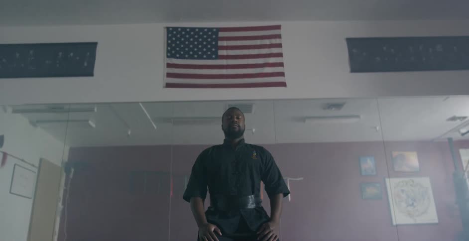 Man closes eyes  wearing martial arts uniform under american flag