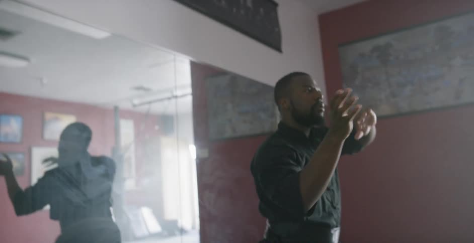 Martial artist running through poses in front of a mirror