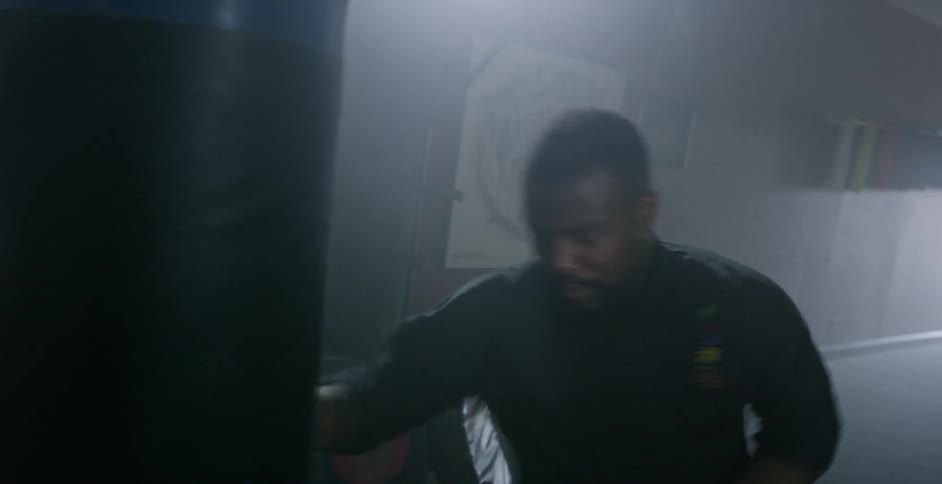 Man punches a punching bag in a gym
