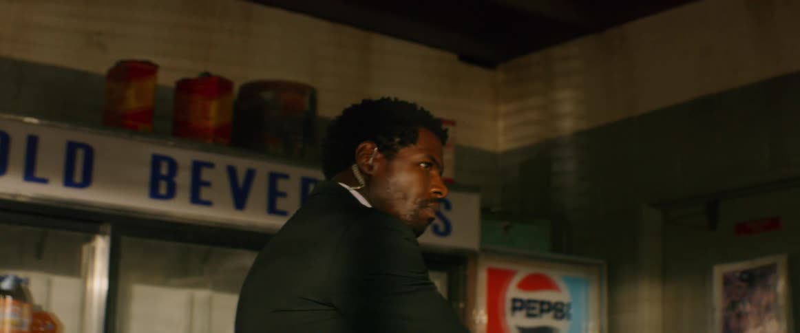A man in a suit looking around a dark room