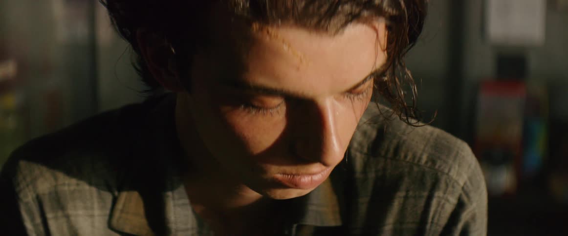 Upset man looks at camera and then down