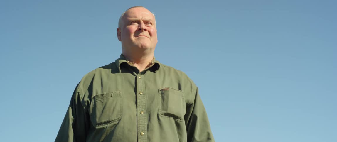 A man is alking outside on a sunny day