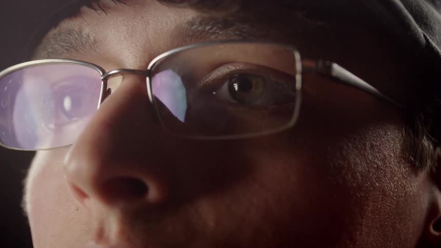 A man is putting glasses on his face