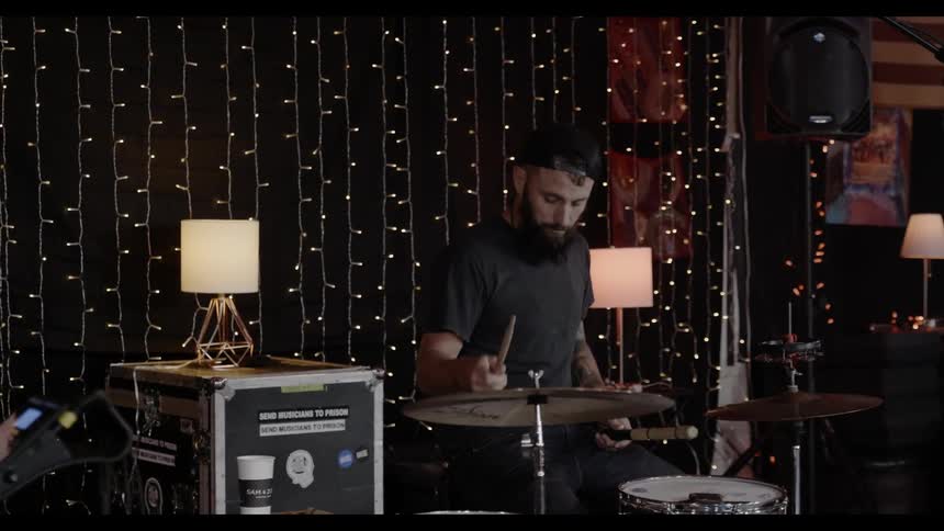 A man plays drums in a music room