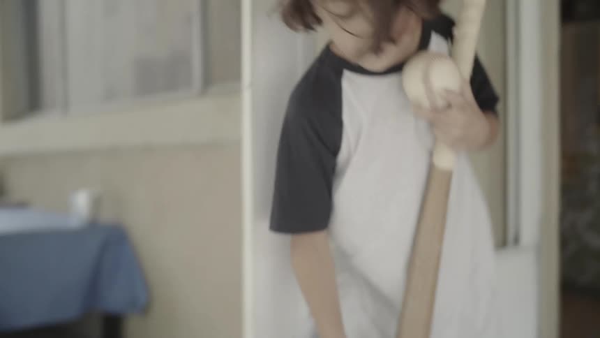 Child bringing their baseball equipment into a house with a person inside