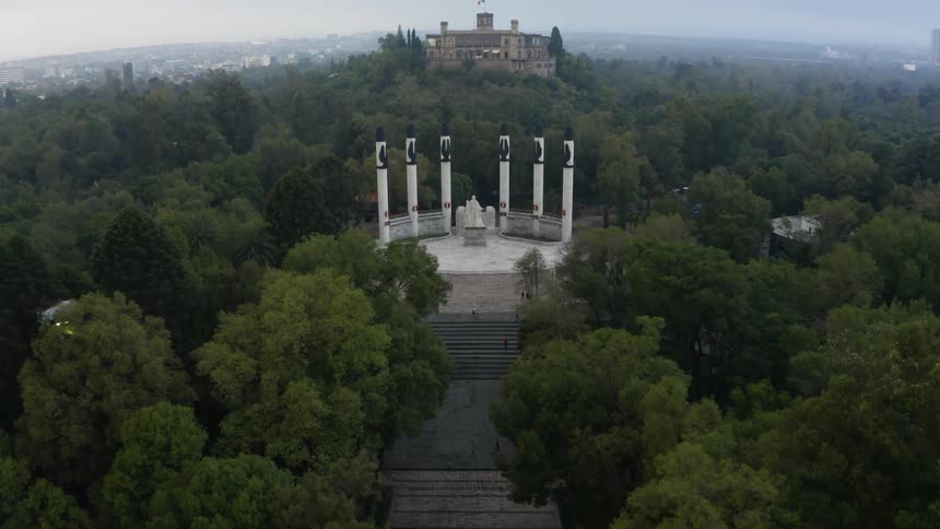 Vehicles drive on a highway past a monument