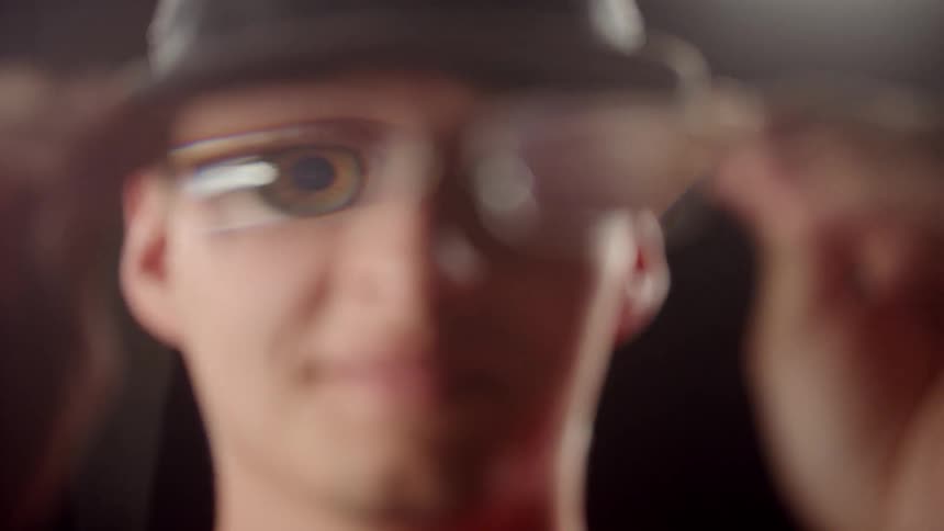 Man Putting On Glasses