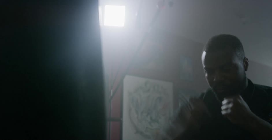 A man is punching the heavy bag in the gym