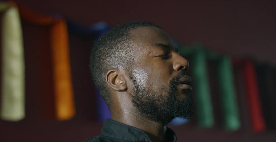 A man is standing with his eyes shut