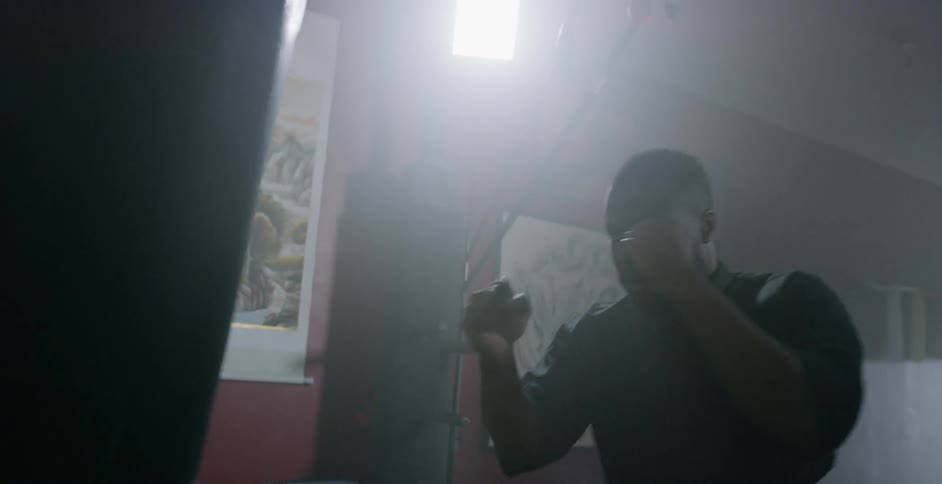 Man punches a punching bag in a gym
