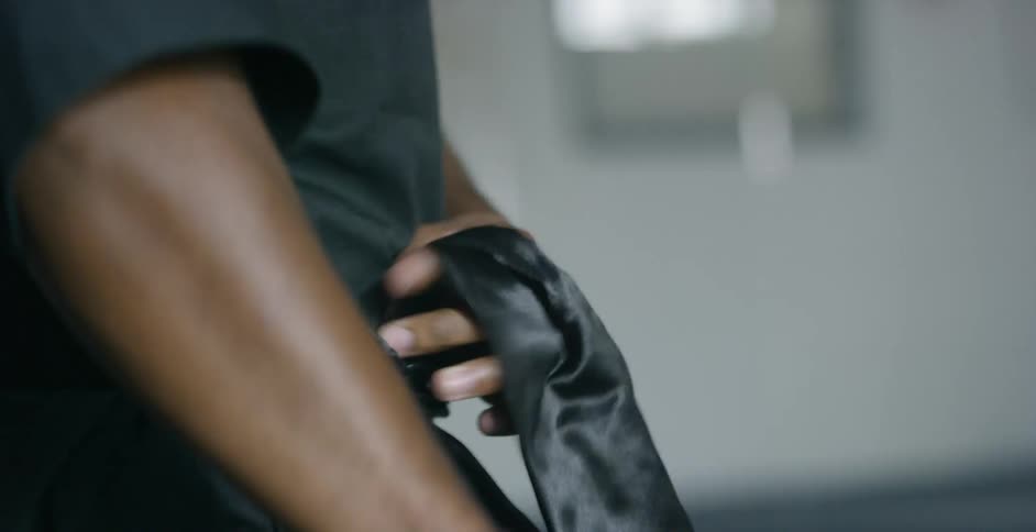 Man ties a black belt on
