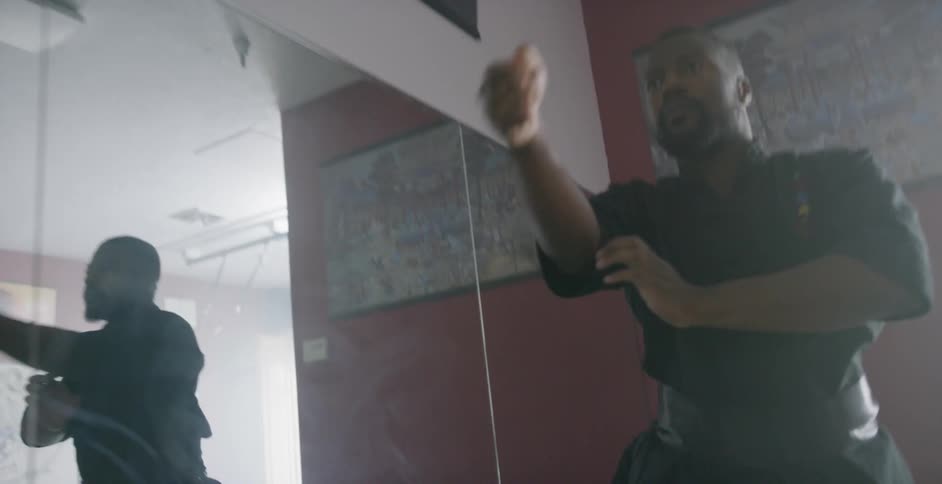 A man practicing his karate move in a dojo