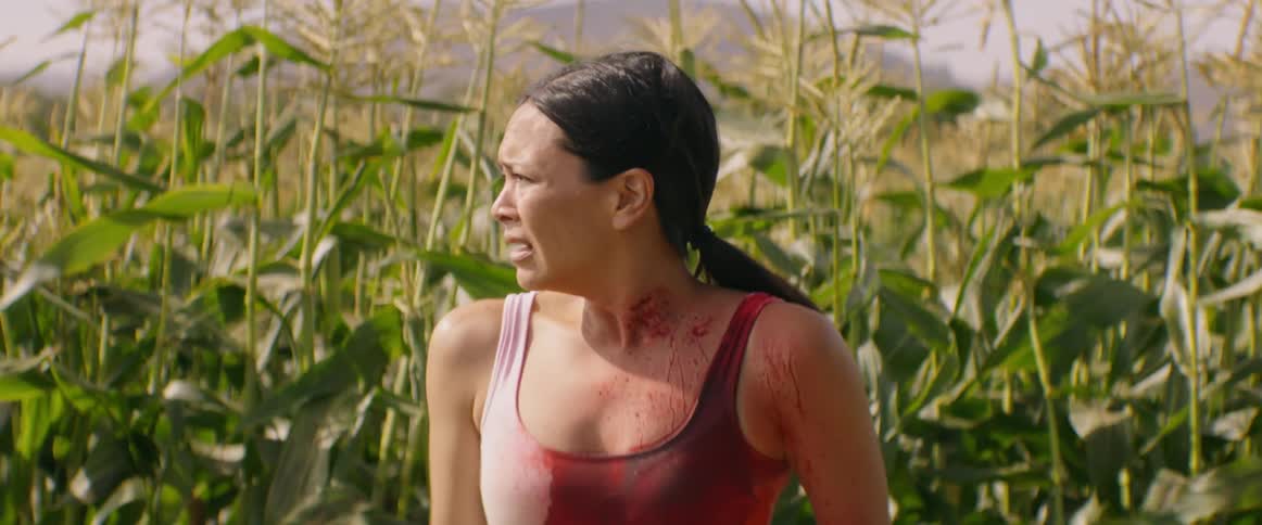 Bloody woman is running out of corn field scared