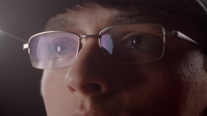 A man is putting glasses on his face