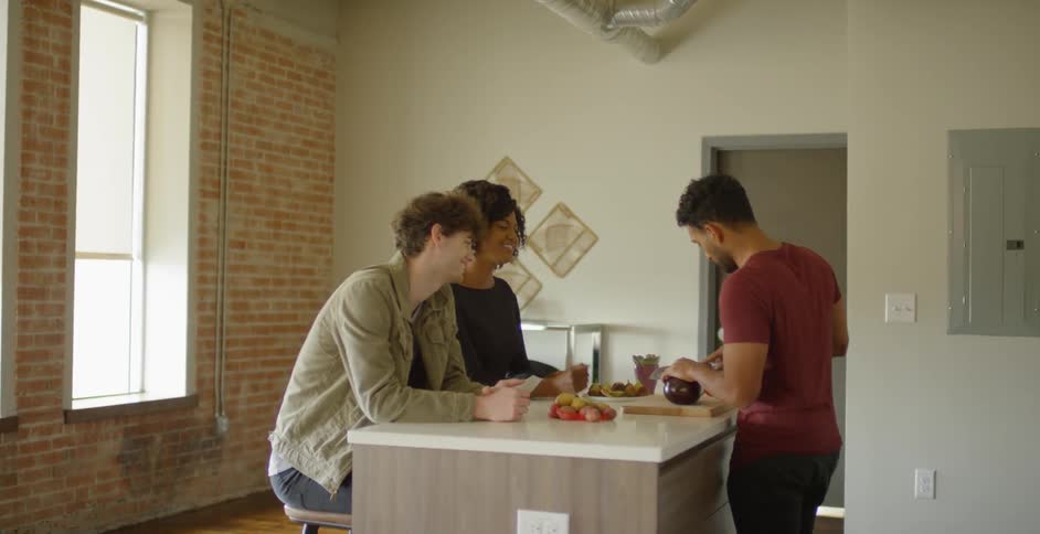 Multiple men and a woman walking into a kitchen