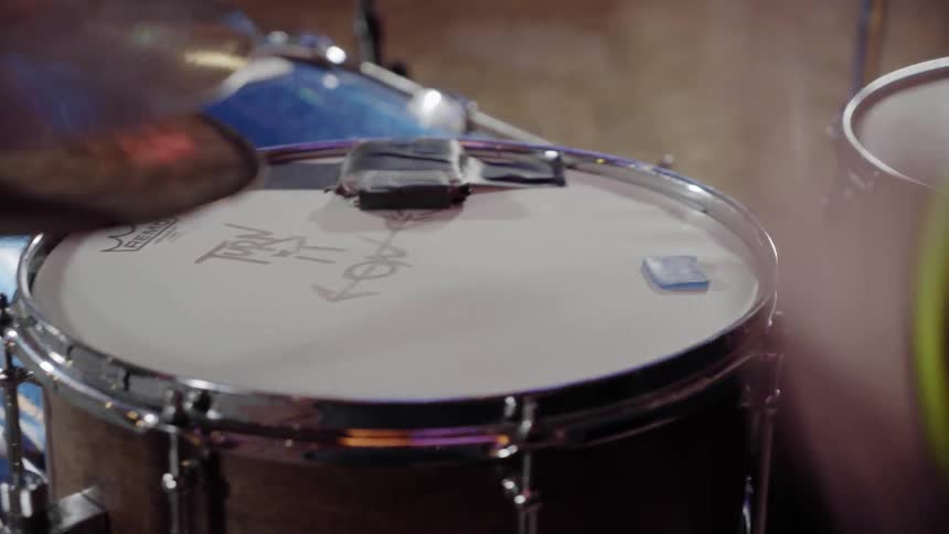 Drummer hits snare drum and opens high hat