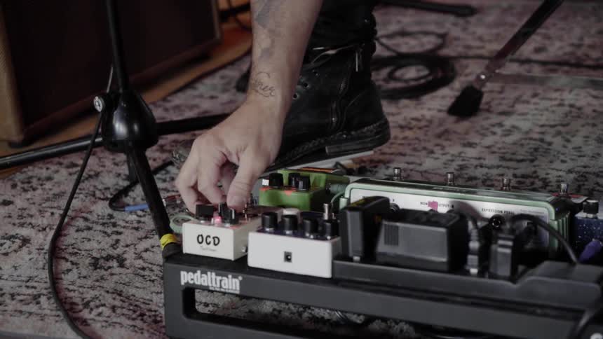 A musician makes adjustments to a guitar pedal